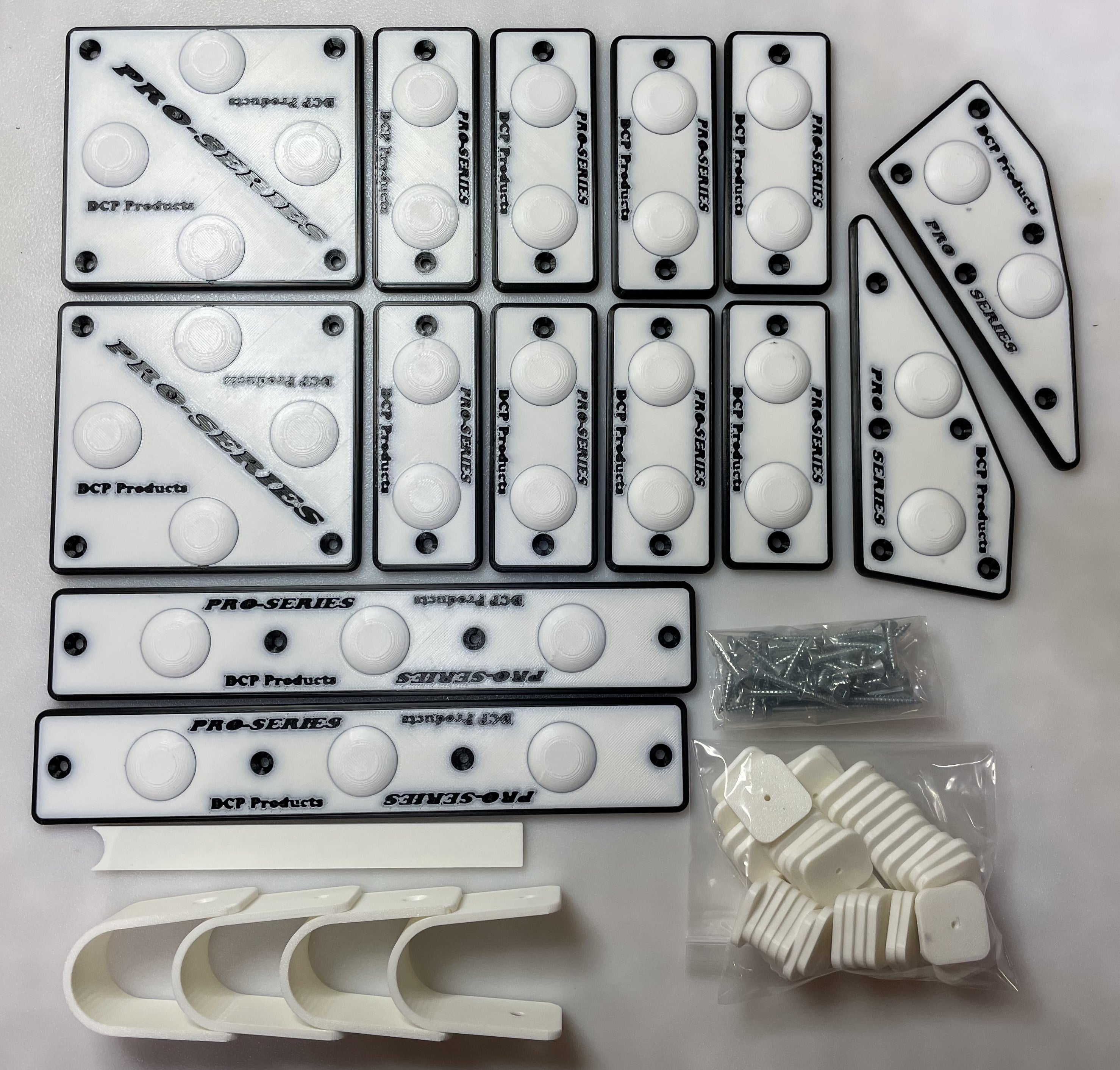 Collection of white DCP Products pro-series parts on a white background