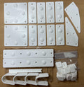 Set of white plastic brackets and components on a wooden surface